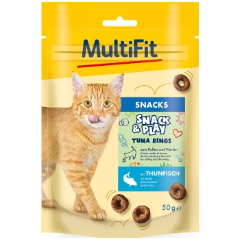 Un chat tigré orange léchant ses lèvres à côté d'un paquet de friandises MultiFit Tuna Rings, étiqueté 'Snack & Play' avec un poids de 50 g.