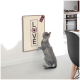 Eine graue Katze steht auf ihren Hinterbeinen und greift nach einem wandmontierten Kratzbrett, das "LOVE" mit einem Katzenlogo darüber zeigt.