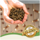 Hände halten einen Haufen dunkler, runder Haustierfutterkibble, mit einem Abzeichen, das "Bewährte Qualität seit über 15 Jahren" und "Beste Qualität" angibt.
