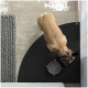 Eine Draufsicht auf einen Hund, der aus einer grauen Schüssel auf einer schwarzen Matte frisst, mit einem strukturierten grauen Teppich in der Nähe.