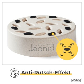 Eine beige Futterschale für Haustiere mit rutschfesten Eigenschaften, die mehrere Löcher für die Futterausgabe aufweist, mit der Aufschrift "Anti-Rutsch-Effekt" am Boden.