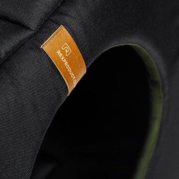 Nahaufnahme eines schwarzen Haustierbettes mit einem Lederetikett, auf dem "REXPRODUCT.COM" eingeprägt ist, das die Qualität und das Branding zeigt.