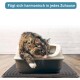 Eine flauschige getigerte Katze liegt am Rand einer Katzentoilette, mit einer Pfote darüber, auf einer strukturierten Matte. Der Text oben sagt: "Fügt sich harmonisch in jedes Zuhause."