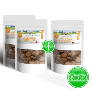 Vier Tüten "Complete-Snack" Hundeleckerlis, mit einer Silhouette eines braunen Hundes, mit einem grünen "+"-Symbol und dem Etikett "Gratis".