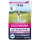 Eukanuba getreidefreier Welpenfutterbeutel, 12 kg, mit einem rennenden Welpen auf einem grasbewachsenen Weg, beschriftet für Hunde im Alter von 1-12 Monaten, unter 25 kg.