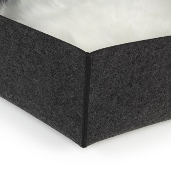 Schwarzes Filz-Haustierbett mit einem weichen weißen Innenraum, das eine Seitenansicht der Struktur des Bettes zeigt.