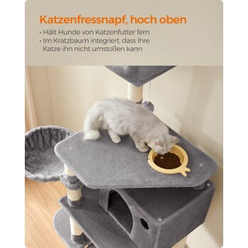 Eine hellgraue Katze, die aus einer gelben, fischförmigen Schüssel auf einem hohen Platz eines grauen Katzenbaums frisst, der ein gemütliches Bett und Kratzpfosten bietet.