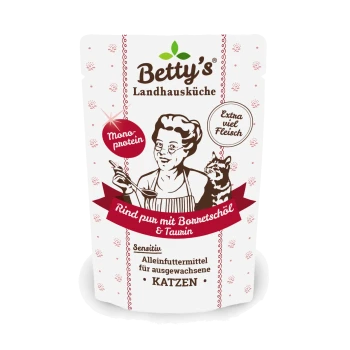 Betty's Landhausküche Katzenfutter zeigt eine Frau, die mit einer Katze kocht, beschriftet mit "Rind pur mit Bonretschöl & Taurin," und betont "Extra viel Fleisch."