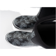 Schwarze Gummistiefel mit floralem Design, mit weißen Umrissen von Blättern und Blumen, von oben betrachtet.
