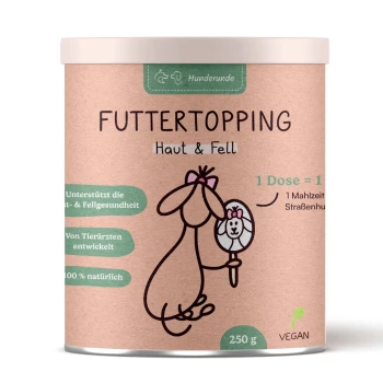Zylindrischer Behälter mit der Aufschrift "Futtertopping Haut & Fell" mit einem Cartoon-Hund, Spiegel und Highlights wie "100% natürlich" und "Vegan."