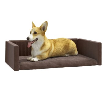 Ein entspannter Corgi liegt auf einem gemütlichen braunen Haustierbett mit erhöhten Seiten und zeigt seinen glücklichen Ausdruck und seine wedelnde Zunge.