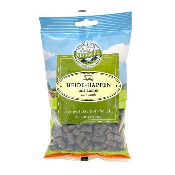 Eine durchsichtige Tüte mit Bellfor Hundeleckerlis, beschriftet "Heide-Happen mit Lamm" mit einem grünen und blauen Design, das besagt: "Der perfekte weiche Snack für unterwegs."