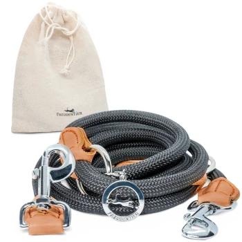 Hundeleine | 3-fach verstellbare Führleine "Harmony" Eine geflochtene schwarze Hundeleine mit Lederakzenten und Metallclips, neben einem beigen Zugbeutel mit der Aufschrift "Freudentier" gewickelt.