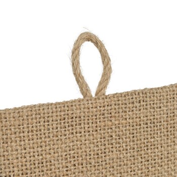 Eine Nahaufnahme eines strukturierten Jutegewebes mit einer kleinen Schlaufe oben, geeignet zum Aufhängen oder Ausstellen von Gegenständen.