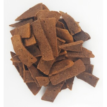 Stos prostokątnych przysmaków dla psów w różnych odcieniach brązu, wyeksponowanych na białym tle.