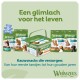 Assortiment Whimzees hondentandverzorgingssnoepjes op lichtgroene achtergrond; Nederlandse kop 'Een glimlach voor het leven' en slogan.