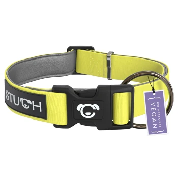 Ein leuchtend gelbes Hundehalsband mit einer schwarzen Schnalle und einem Anhänger, auf dem steht "PETA APPROVED VEGAN." Das Halsband trägt das Wort "STUCH" in weißen Buchstaben.