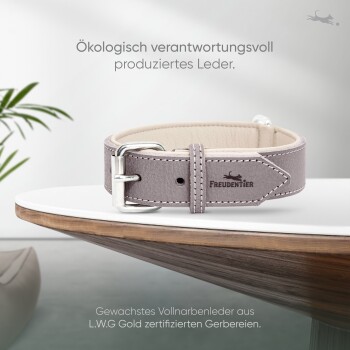 Ein stilvoller grauer Leder-Hundehalsband, der auf einem Holztisch präsentiert wird, mit dem Markennamen "Freudentier" und Text über umweltfreundliche Produktion.