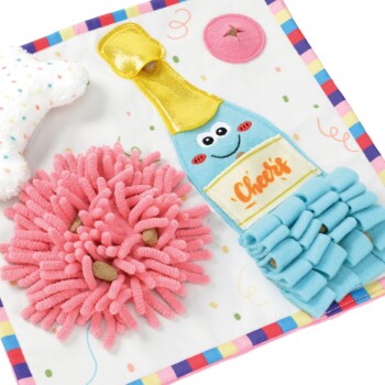 Ensemble de jouets pour animaux de compagnie colorés avec une bouteille de champagne en peluche bleue avec un visage souriant étiqueté "Cheers," une fleur rose duveteuse, et une étoile blanche.