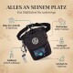 Eine schwarze Leckerlitasche für Haustiere mit Kordelzug, Netzfach und blauer Abfallbeutelspender; eine Hand zieht einen Beutel heraus. Text: "Robust & Funktional."