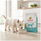 Weißer West Highland Terrier schnüffelt an einem Napf neben einer Tüte Select Gold Medica Veterinary Diet Hypoallergen.