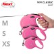 Eine Hand hält eine pinke Flexi-Retractable-Hundeleine, mit drei Größen (M, S, XS) daneben angezeigt, beschriftet 'NEW CLASSIC GURT'.