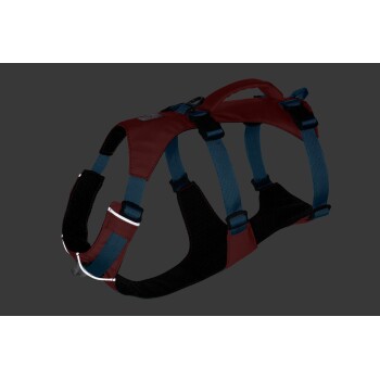 Ein rotes und blaues Hundegeschirr mit verstellbaren Riemen und einem gepolsterten Brustbereich, vor einem dunklen Hintergrund präsentiert.