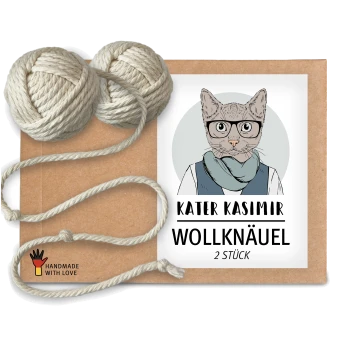Eine Kraftpapierverpackung mit einer Cartoon-Illustration einer Katze, beschriftet mit 'KATER KASIMIR WOLLKNAÜEL 2 STÜCK,' mit zwei Wollknäueln daneben.