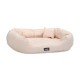 Ein plüschiges, beiges Haustierbett mit runder Form und weichen Kissen, mit einem kleinen passenden Kissen und einem schwarzen Logo-Tag.