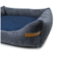 Ein plüschiges, dunkelgraues Haustierbett mit einem weichen blauen Innenraum und einem Lederetikett mit der Aufschrift "RexProduct.com" an der Seite.