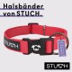 Roter Hundehalsband von STUCH mit einer schwarzen Schnalle und einem Metallring, mit einem Etikett, das "Vegan" sagt, und dem Text "Halsbänder von STUCH."