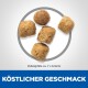 Fünf Haustierfutterpellets in einem Kreis, etwa 7 x 6,5 mm groß, mit dem Text "Köstlicher Geschmack" darunter.