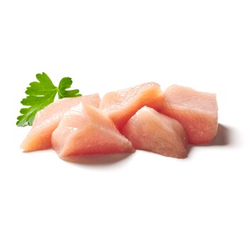 Rohe rosa Hähnchenbruststücke mit einem grünen Petersilienblatt auf weißem Hintergrund.