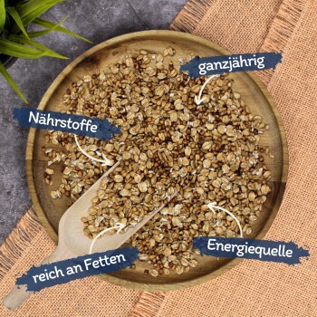 Eine Holzschale mit gemischten Samen und Körnern mit einem Schaufel, beschriftet mit "Nährstoffe," "ganzjährig," "reich an Fetten," und "Energiequelle."