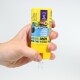 Une main pressant un conteneur jaune étiqueté "Pro Shrimp" avec des accents bleus, distribuant de petites granules pour la nourriture des poissons.