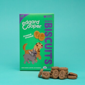 Boîte verte de biscuits pour chiens Edgard Cooper avec des chiens de dessin animé sur le devant, avec le texte "Bravo Biscuits" et "Crouch Crouch."