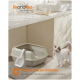 Katzentoilette mit Schaufel auf einer Matte neben einer weiß-beigen Katze in einem hellen Badezimmer, Text auf Deutsch.