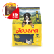 Gelber Josera Hundefutterbeutel mit der Aufschrift 'Kids', einem Welpenfoto, einer Hühnerillustration, einem 'NEW DESIGN'-Badge und dem Text 'Junior'.