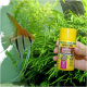Eine Hand hält einen gelben Behälter mit JBL Pro Novo Bel Fischfutterflocken, mit einem Schwarm von Engelfischen, die in einem üppigen Aquarium schwimmen.