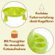 Grüner kegel­förmiger Futterspender mit Trennwand; sichtbarer deutscher Text: „Perfekte Futterverteilung; Mit Fressgitter“.