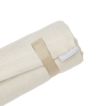 Gerollte beige Haustierdecke, gesichert mit einem hellbraunen Riemen, die ein einfaches, strukturiertes Stoffdesign zeigt.