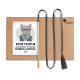 Ein Kartonpaket mit einer Cartoon-Katze in Brille und Schal, beschriftet mit "KATER KASIMIR RANGELANGEL GRAU," mit einem Holzstock und grauem Quastenschnur.