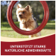 Ein flauschiger Hund schaut durch einen roten Gummiring im Gras, mit Text darunter: "Unterstützt starke natürliche Abwehrkräfte."
