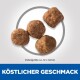 Vier Tierfutterpellets auf einem hellen Hintergrund, mit einem Durchmesser von 12 mm und "KÖSTLICHER GESCHMACK" in fettem blauen Text.