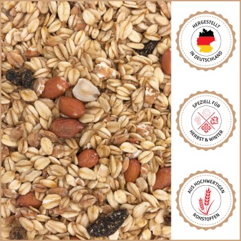 Nahaufnahme von gemischten Haferflocken, Nüssen und Samen mit deutschen Textaufklebern: "Made in Germany", "Für Herbst & Winter" und "Aus hochwertigen Rohstoffen".