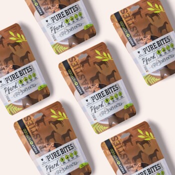 Eine Sammlung von Haustierfutterpaketen mit der Aufschrift "PURE BITES Pferd", mit Illustrationen von Pferden und grünen Blattelementen, auf einem hellen Hintergrund.