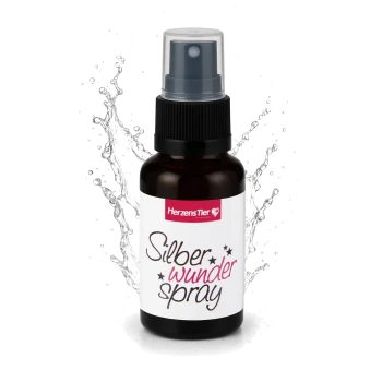 Braune Sprühflasche mit der Aufschrift „HerzensTier Silber wunder spray“ vor einem Wasser-Spritzhintergrund.