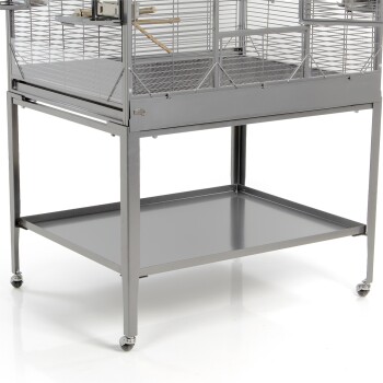 Ein stabiler grauer Metallvogelkäfig auf Rädern, mit einem geräumigen oberen Bereich mit horizontalen Stangen, einer Holzstange und einem unteren Regal zur Aufbewahrung.
