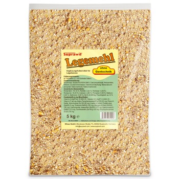 Nahaufnahme von gemischtem Vogelfutter mit gespaltenem Mais, Hirse und anderen Körnern auf einer hellbraunen Oberfläche.