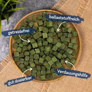 Holzschale mit grünen Würfel-Pellets auf Jute, Beschriftung: getreidefrei, ballaststoffreich, gut dosierbar, Verdauungshilfe